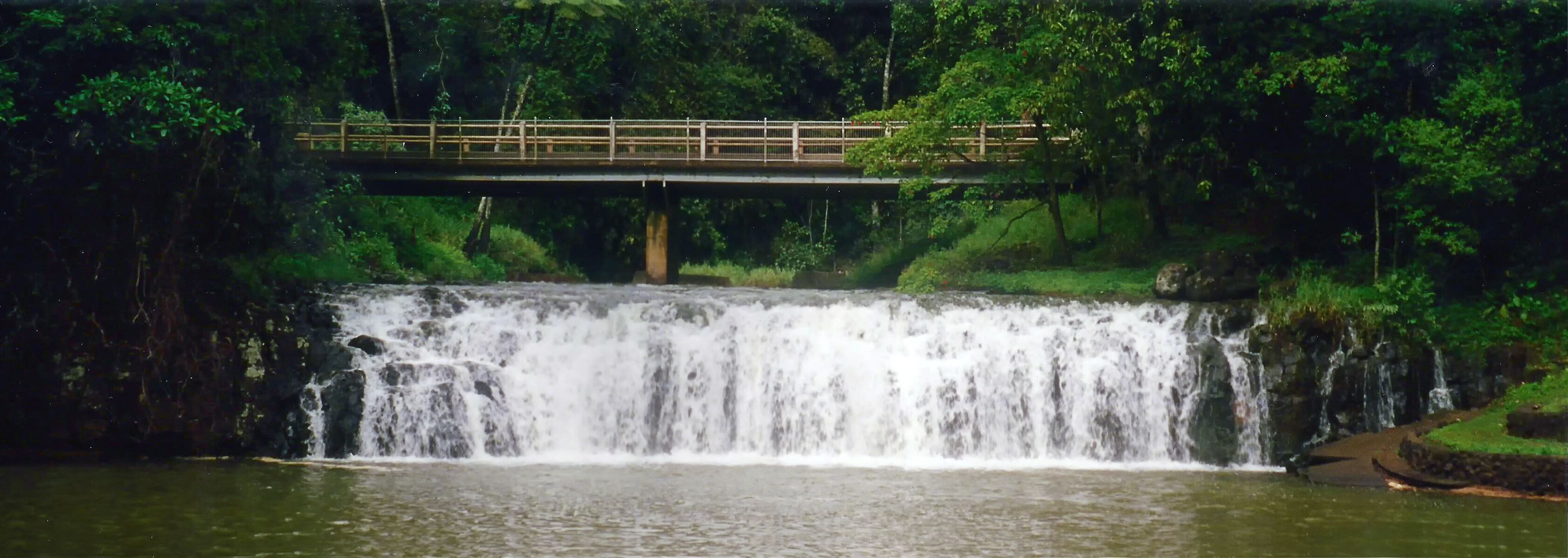 A waterfall with a bridge over it.