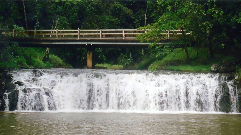 A waterfall with a bridge over it.