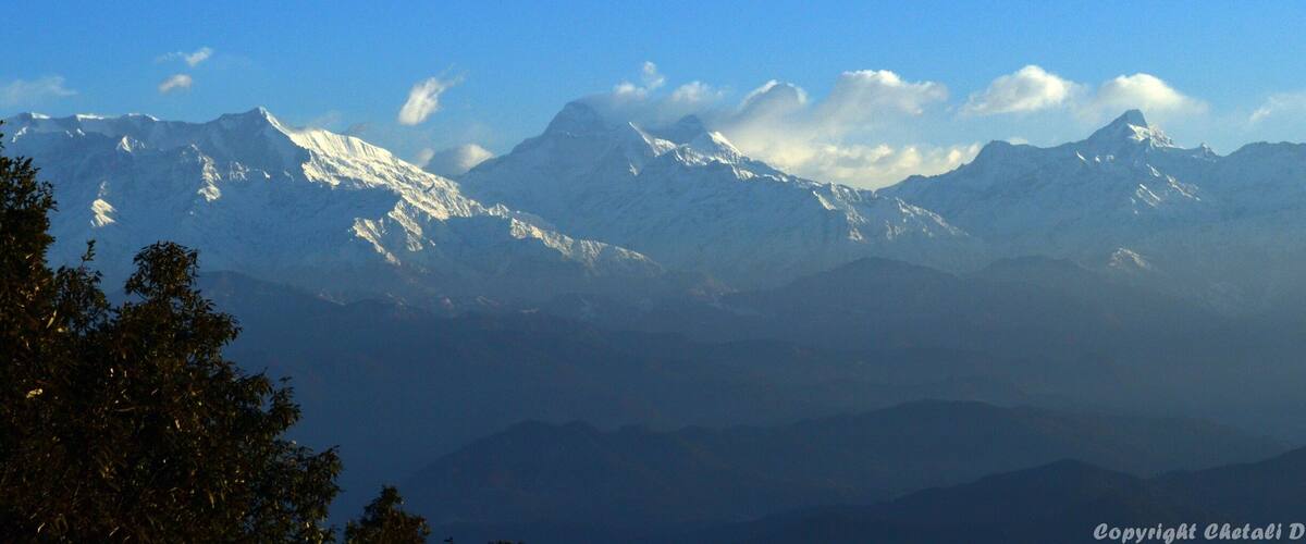 A range of snow-capped mountains under a clear blue sky.