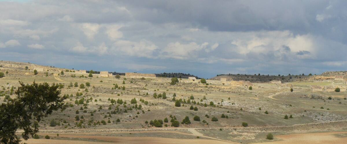 A hilly landscape with scattered buildings and trees.