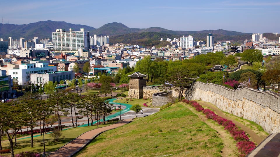 A cityscape with modern buildings, a traditional stone tower, and a river.