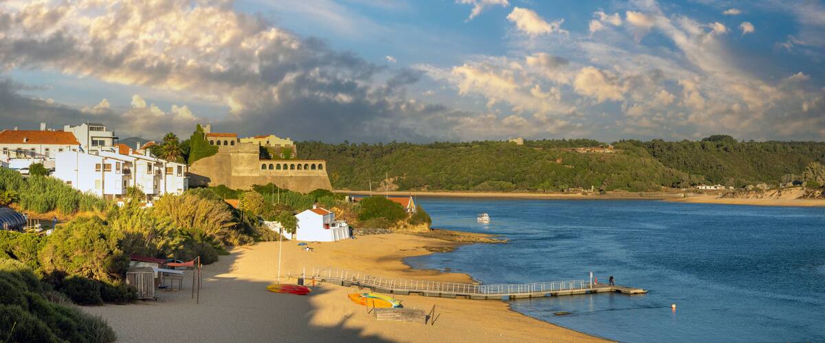 Une ville côtière dotée d’une plage, d’une jetée et d’une structure ressemblant à un château.