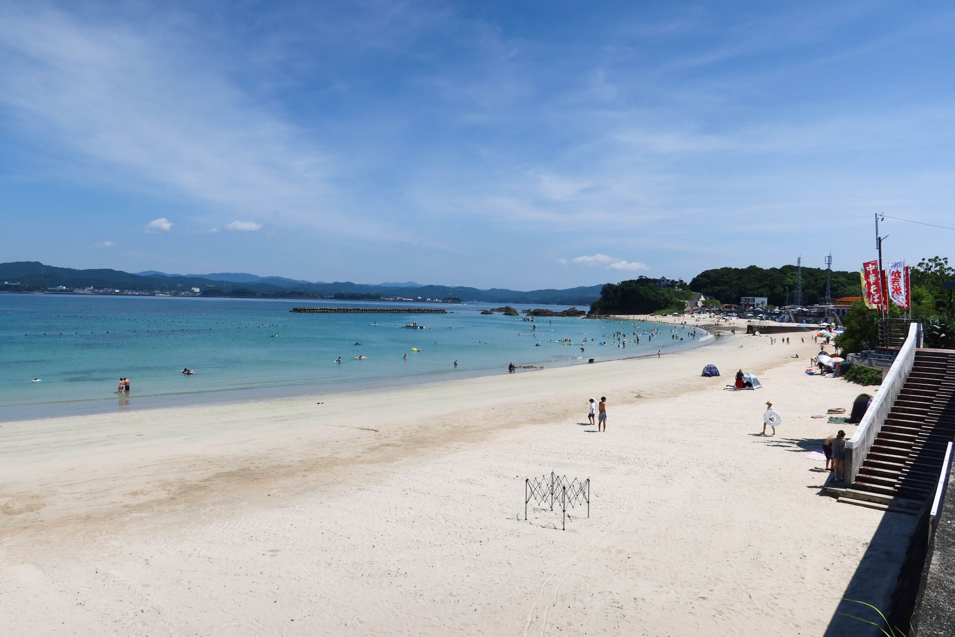 good weather greenish blue sea and beach withe people swimming in the sea and playing on the sad taken in Ise, Mia, Japan