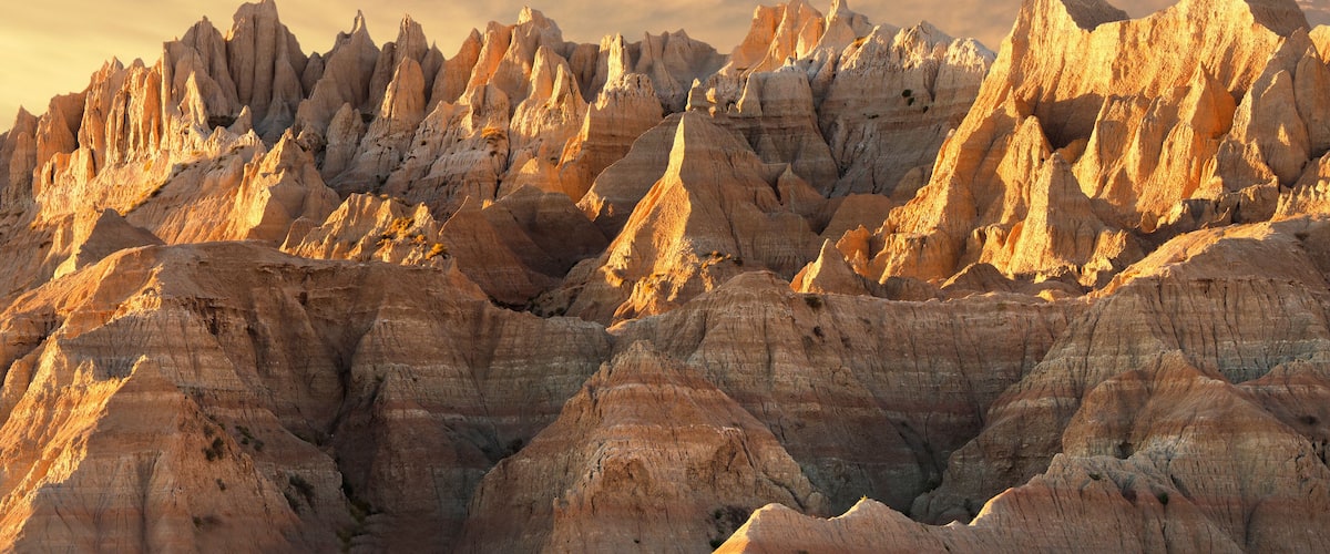 A rugged mountain range with sharp peaks and a dramatic sky.
