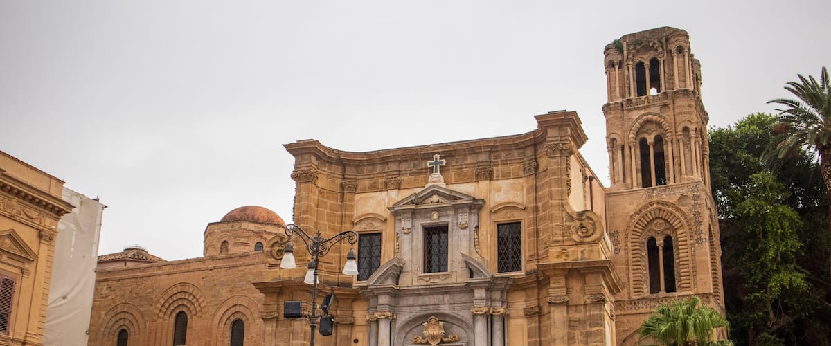 A historic building with a central dome, arched windows, and a bell tower.