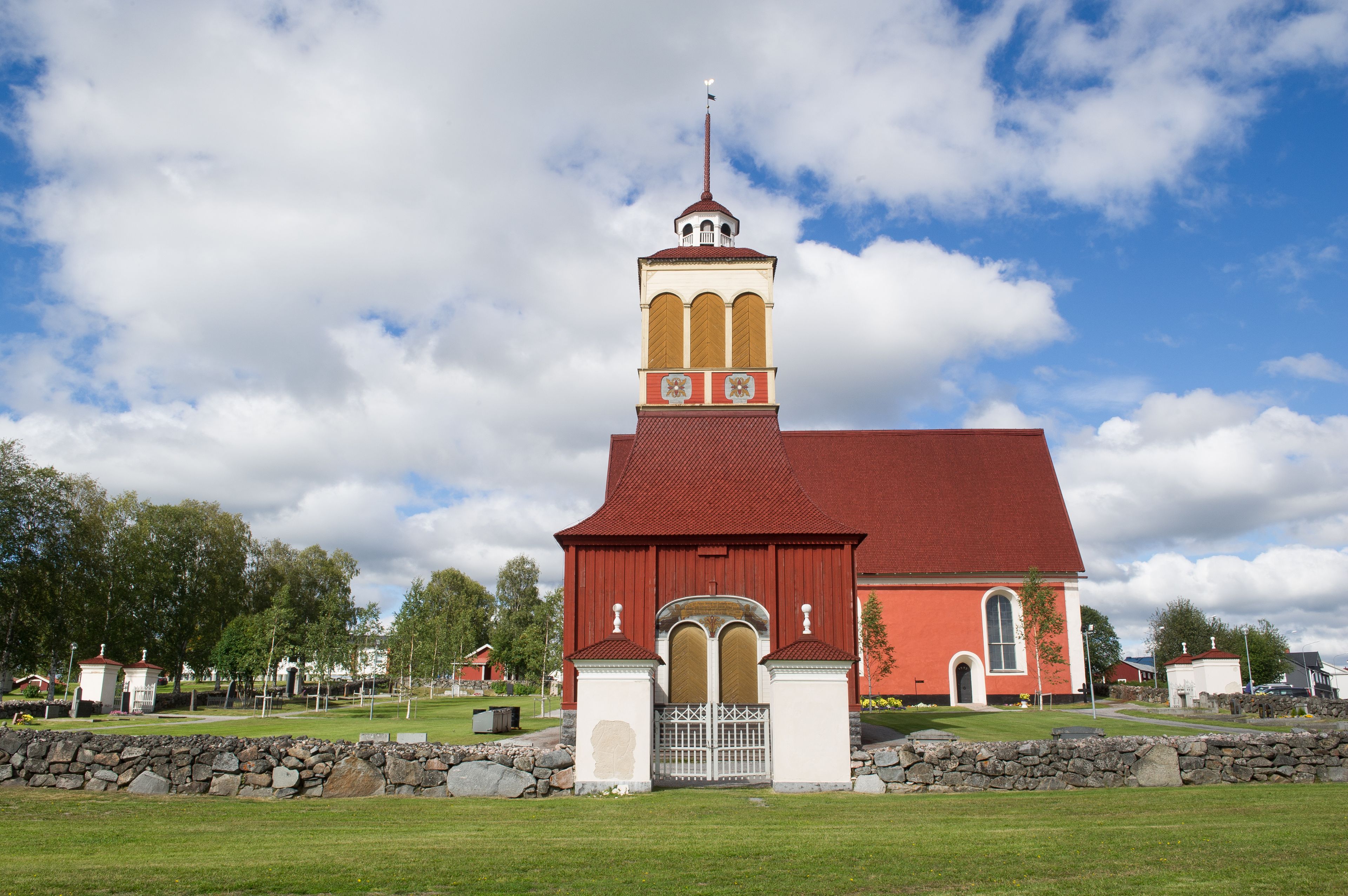 A church with a red roof and a tall bell tower.