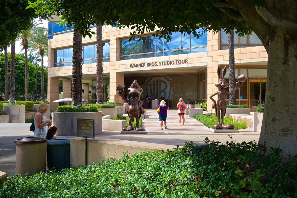 Warner Bros. Studio Tour building with palm trees and a statue of a character.