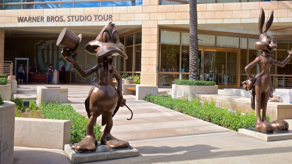 A bronze statue of a character holding a cup and a sign reading "Warner Bros. Studio Tour".