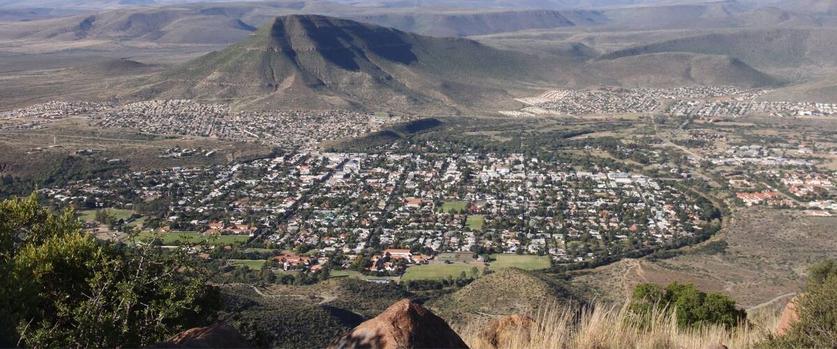 A town nestled in a valley with a prominent mountain in the background.