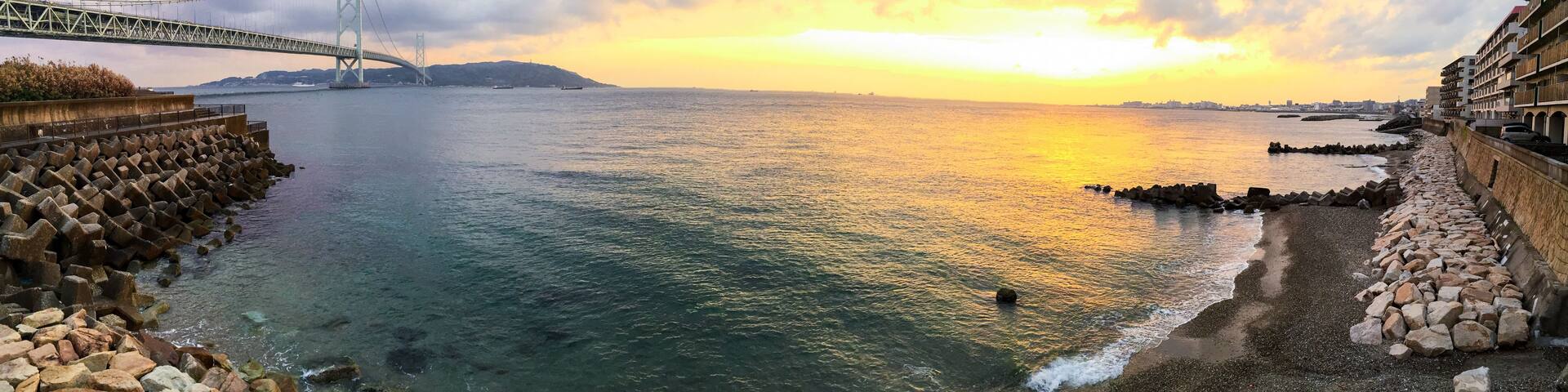 Panoramic sunset view of the sea ,the Akashi-Kaikyo Bridge links the city of Kobe on the Japanese mainland of Honshu to Iwaya on Awaji Island in Japan.
