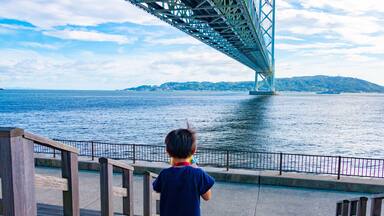 Akashi Kaikyo Bridge and a boy. Tarumi-ku, Kobe City, Hyogo Prefecture, Japan