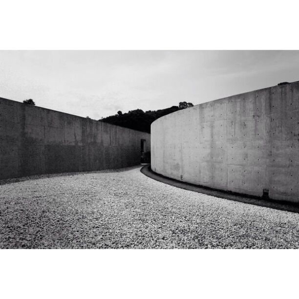 A concrete pathway curving between two walls.
