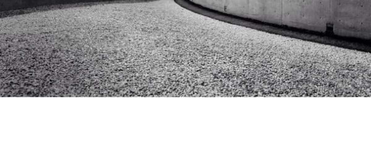 A concrete pathway curving between two walls.