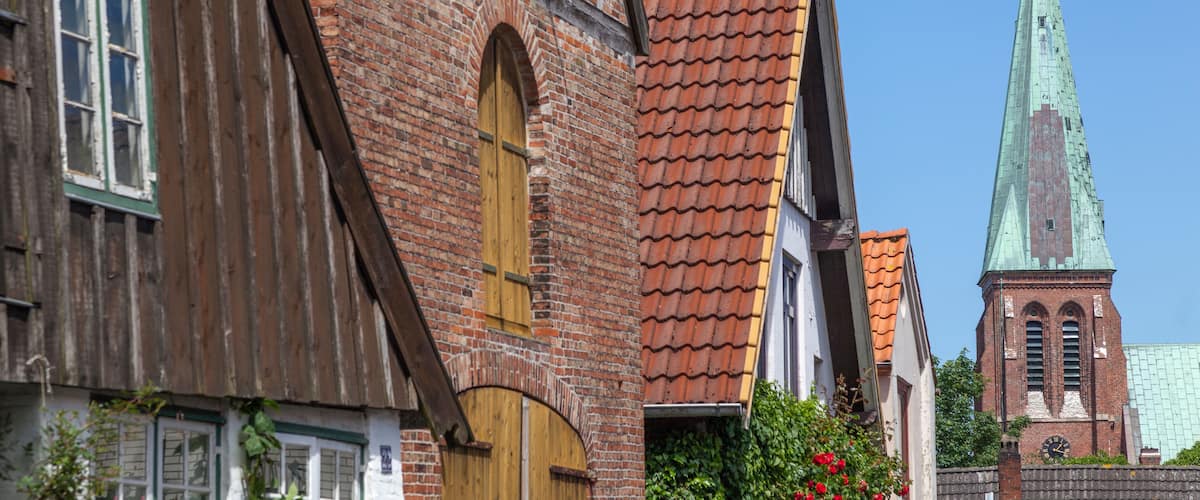 A historic building with a wooden facade and a brick tower with a clock.