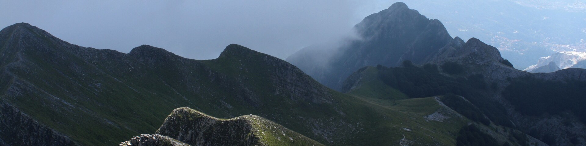 A mountainous landscape with rocky outcrops and grassy slopes.