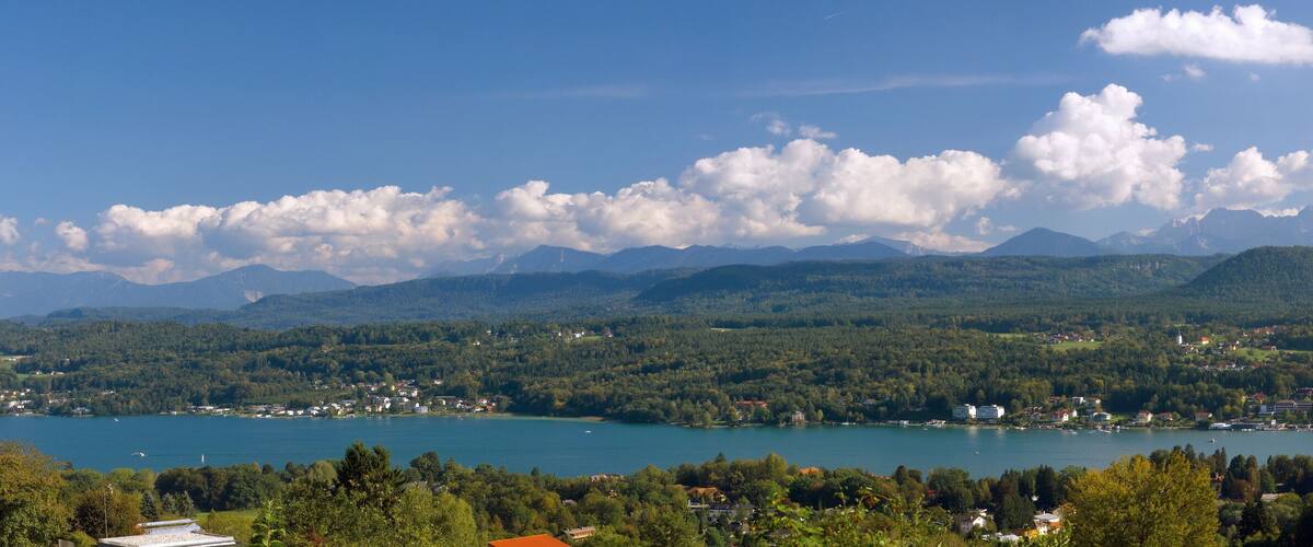 A lake surrounded by mountains and a town with buildings and boats.