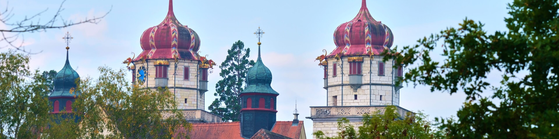 Colorful church towers stand out against a clear sky in a serene landscape