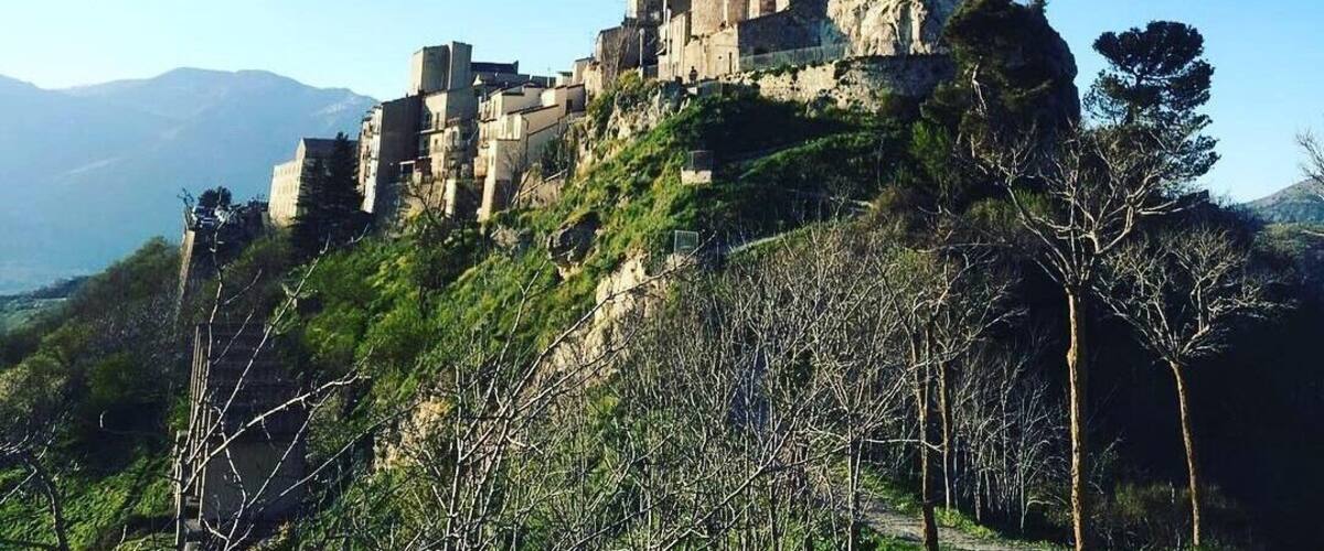 A medieval castle perched on a hill with a clear sky.