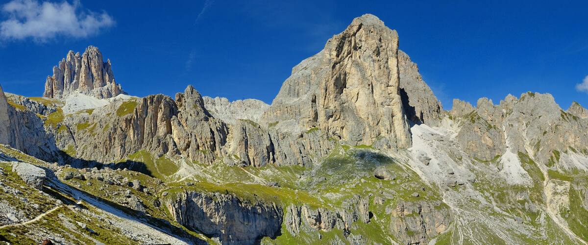 A rugged mountain range with prominent peaks and a clear blue sky.
