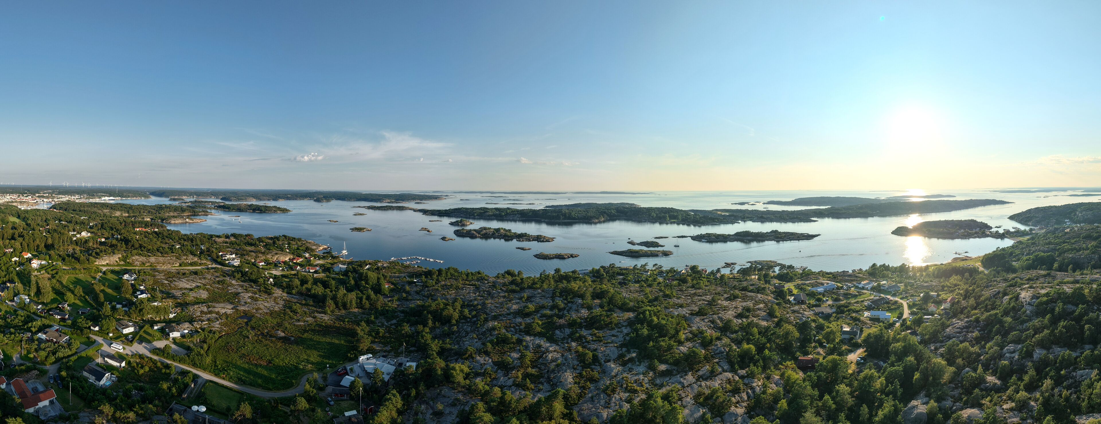 Panoramic Aerial View of Coastal Archipelago Near Strömstad, Sweden with Forested Terrain, Scattered Islands, and Sunlight Reflecting on Calm Sea