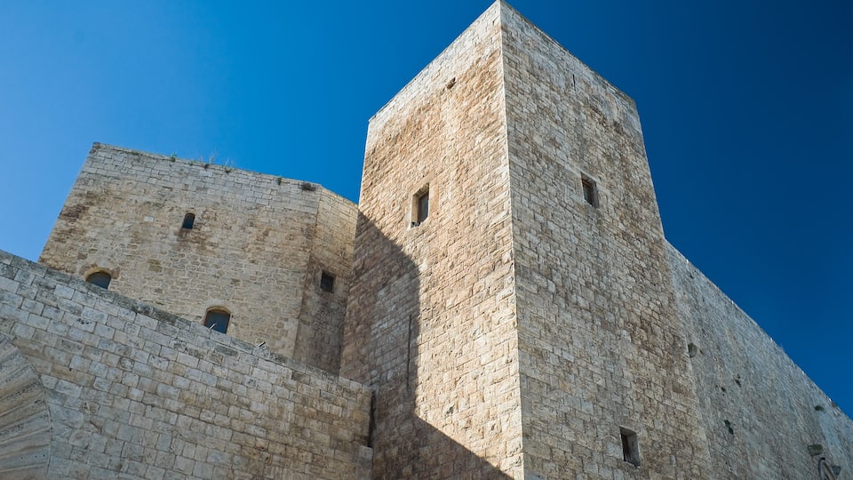 A stone tower with arched windows and a clear blue sky.