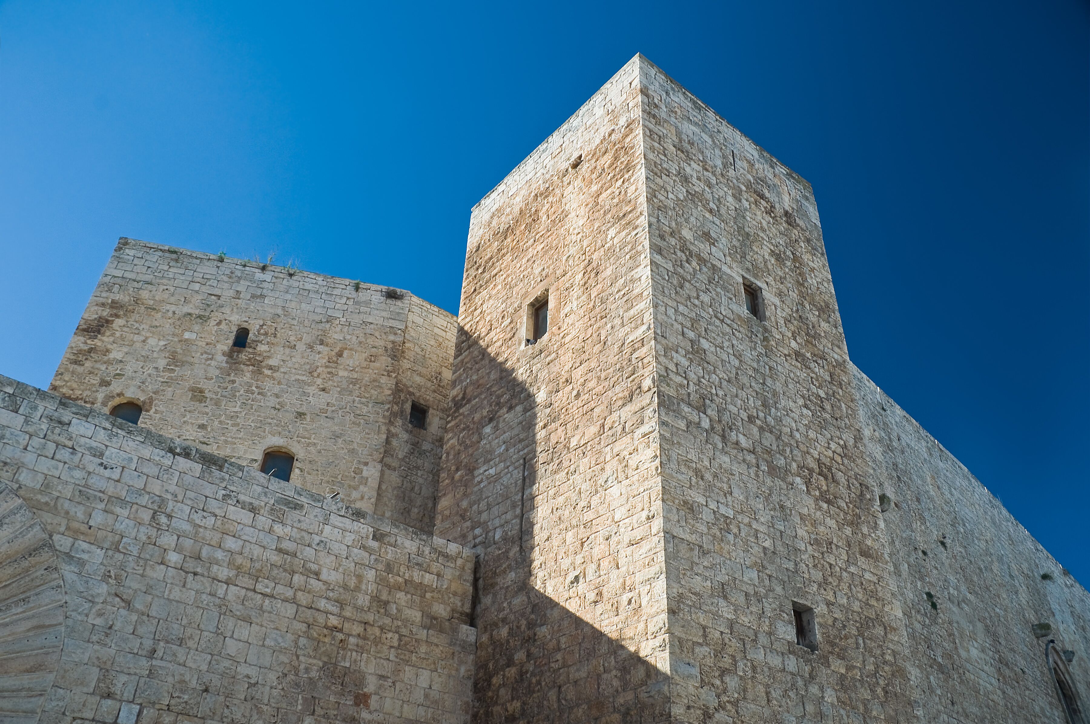 A stone tower with arched windows and a clear blue sky.