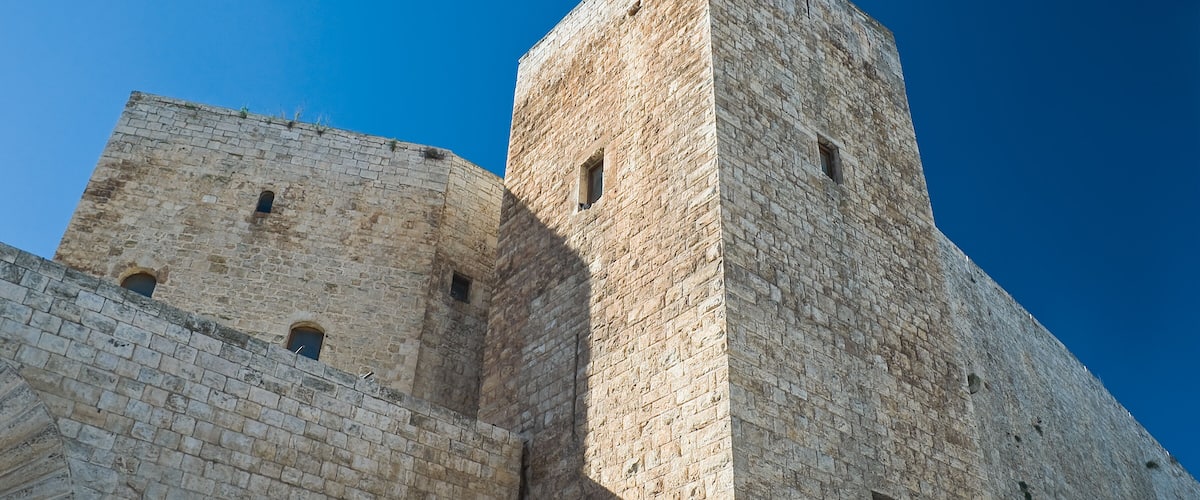 A stone tower with arched windows and a clear blue sky.