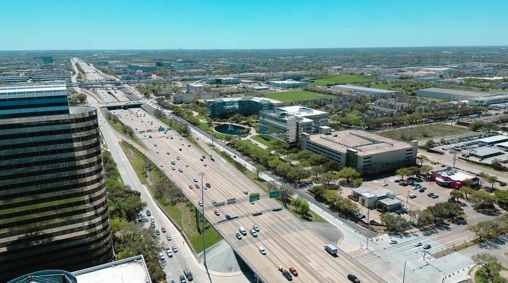 Modern glass office buildings, corporate office headquarters landmark in Westchase business district looking down busy Sam Houston Tollway and Richmond Avenue intersection, highway traffic aerial