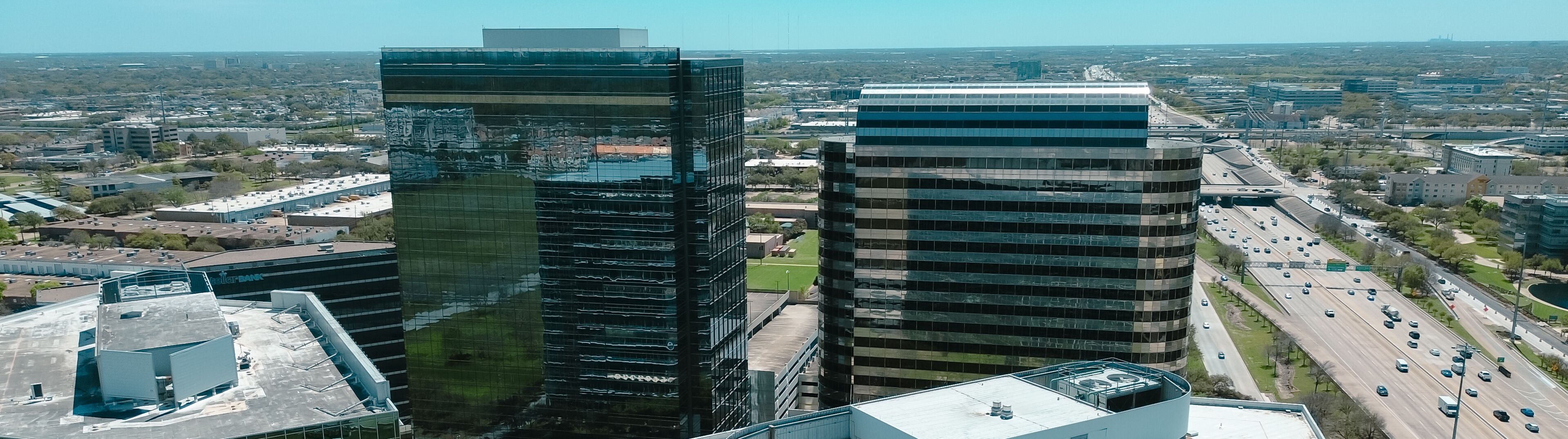 Panorama aerial view rooftop of modern glass office buildings, corporate office headquarters in Westchase business district, busy Sam Houston Tollway and Richmond Ave intersection, mixed use area