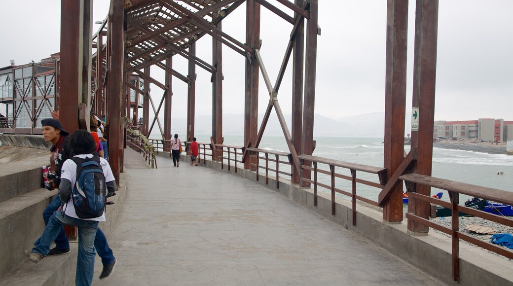 Punta Hermosa que incluye vista general a la costa y un puente colgante o una pasarela y también un pequeño grupo de personas