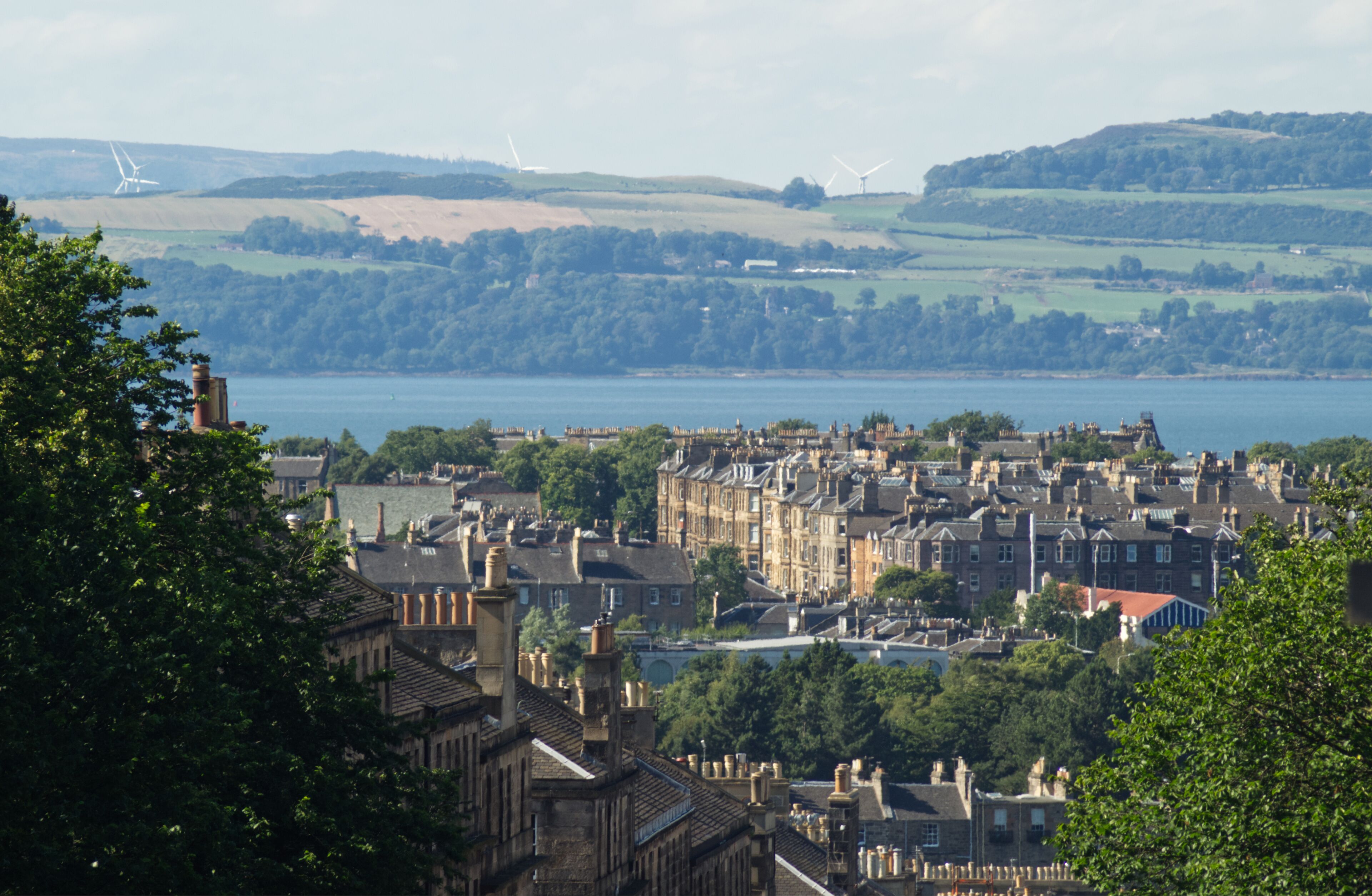 A landscape view of the residential area of Broughton in Edinburgh, Scotland, UK and the coast of Fife in the background with visible heat rising from a heatwave.