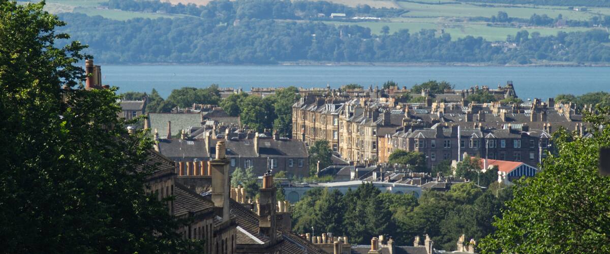 A landscape view of the residential area of Broughton in Edinburgh, Scotland, UK and the coast of Fife in the background with visible heat rising from a heatwave.