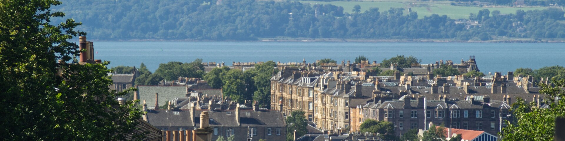 A landscape view of the residential area of Broughton in Edinburgh, Scotland, UK and the coast of Fife in the background with visible heat rising from a heatwave.