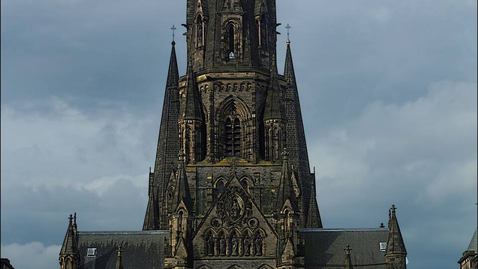 Une vaste église de style gothique, dotée d’une haute flèche et d’une architecture complexe.