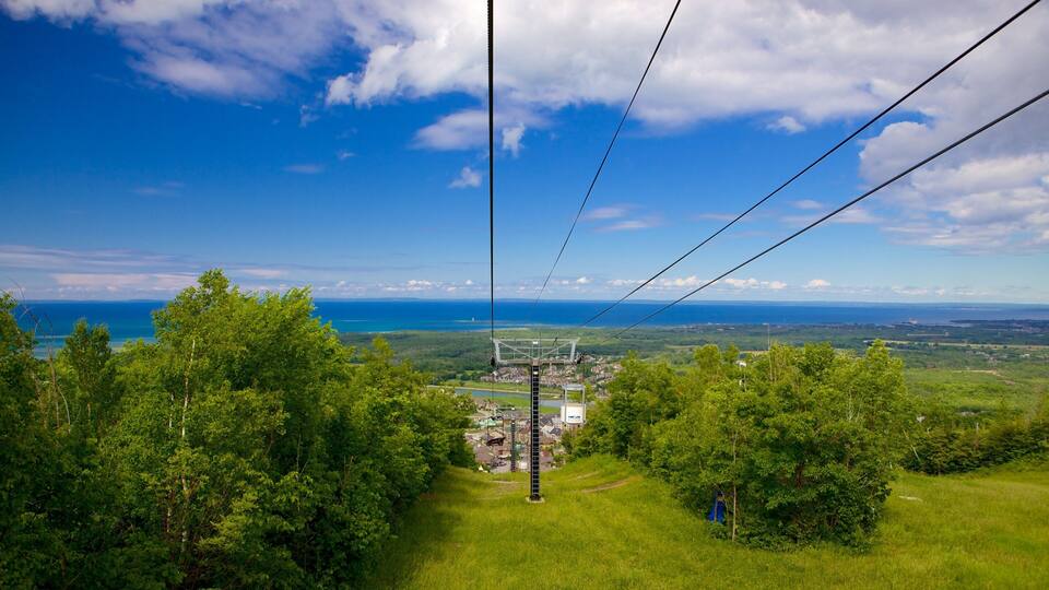 A cable car system with a view of a coastal landscape and a town below.