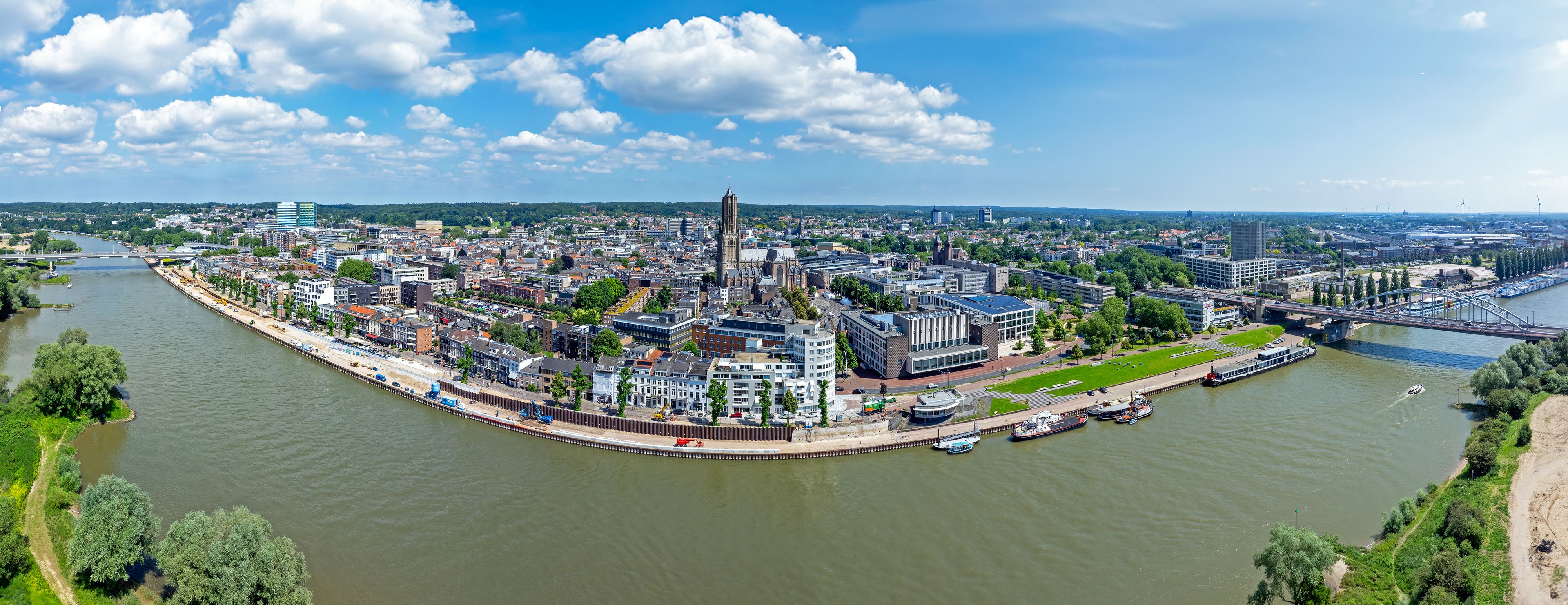 A river city with a prominent church, a bridge, and a modern building.