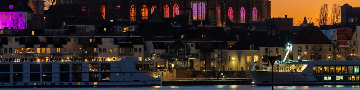 A historic church with a tall spire and stained glass windows, set against a twilight sky.