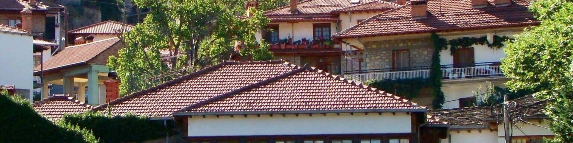 A hillside town with terracotta-roofed buildings, including a hotel named 'HOTEL GALAXY'.