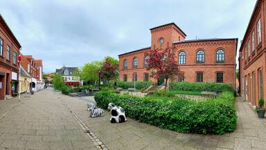 Beautiful historic red brick building of the music school in Lemvig with forecourt, Østergade, red flowering trees, Lemvig, West Jutland, Denmark