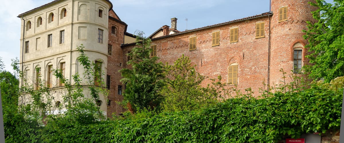 A historic building with a round tower and a white facade.