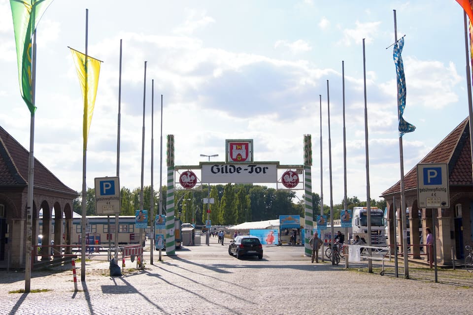 Een stadsingang met een bord waarop "Gilde-Tor" staat en een parkeersbord.