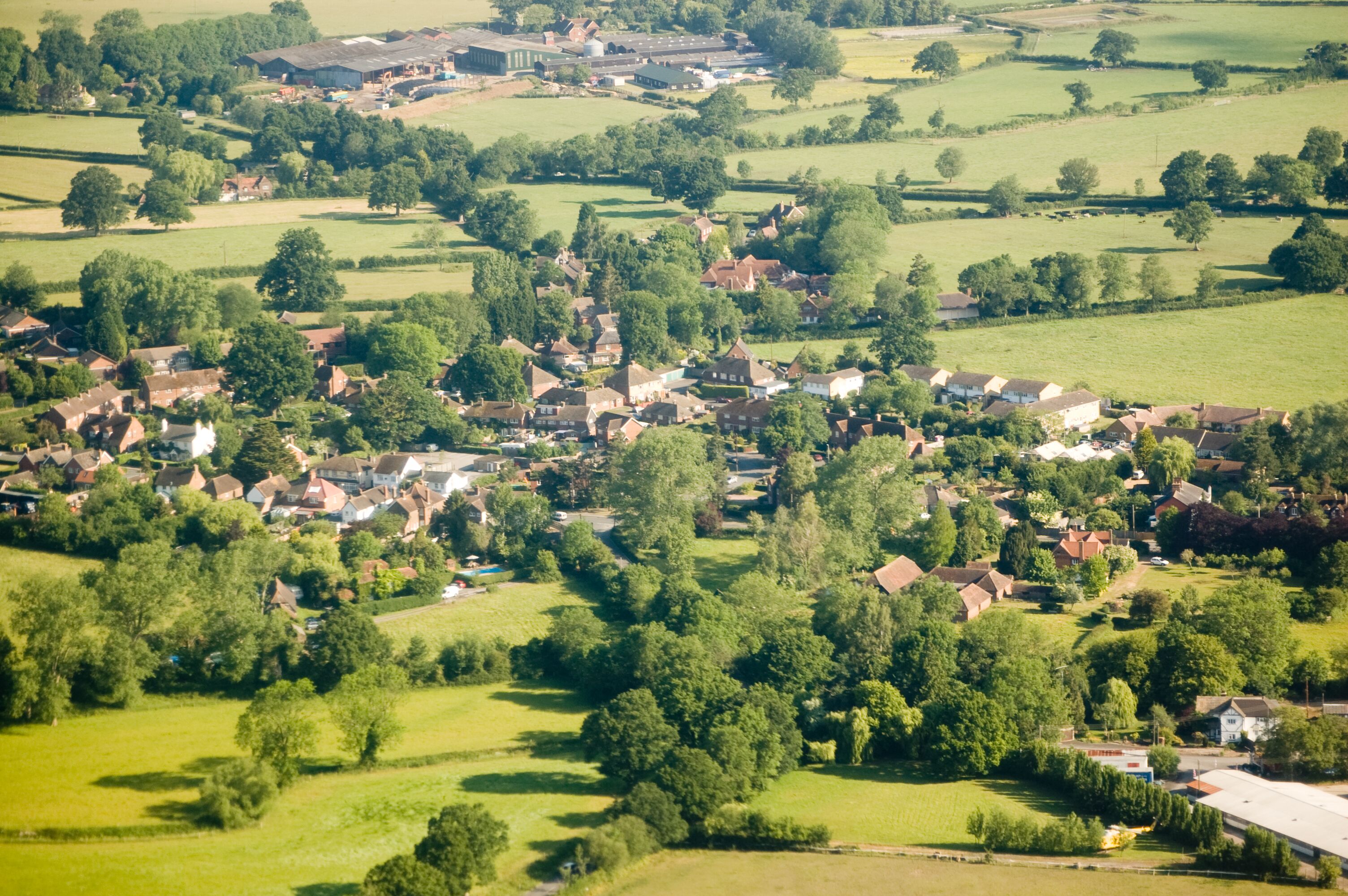 A rural village with houses, fields, and scattered trees.