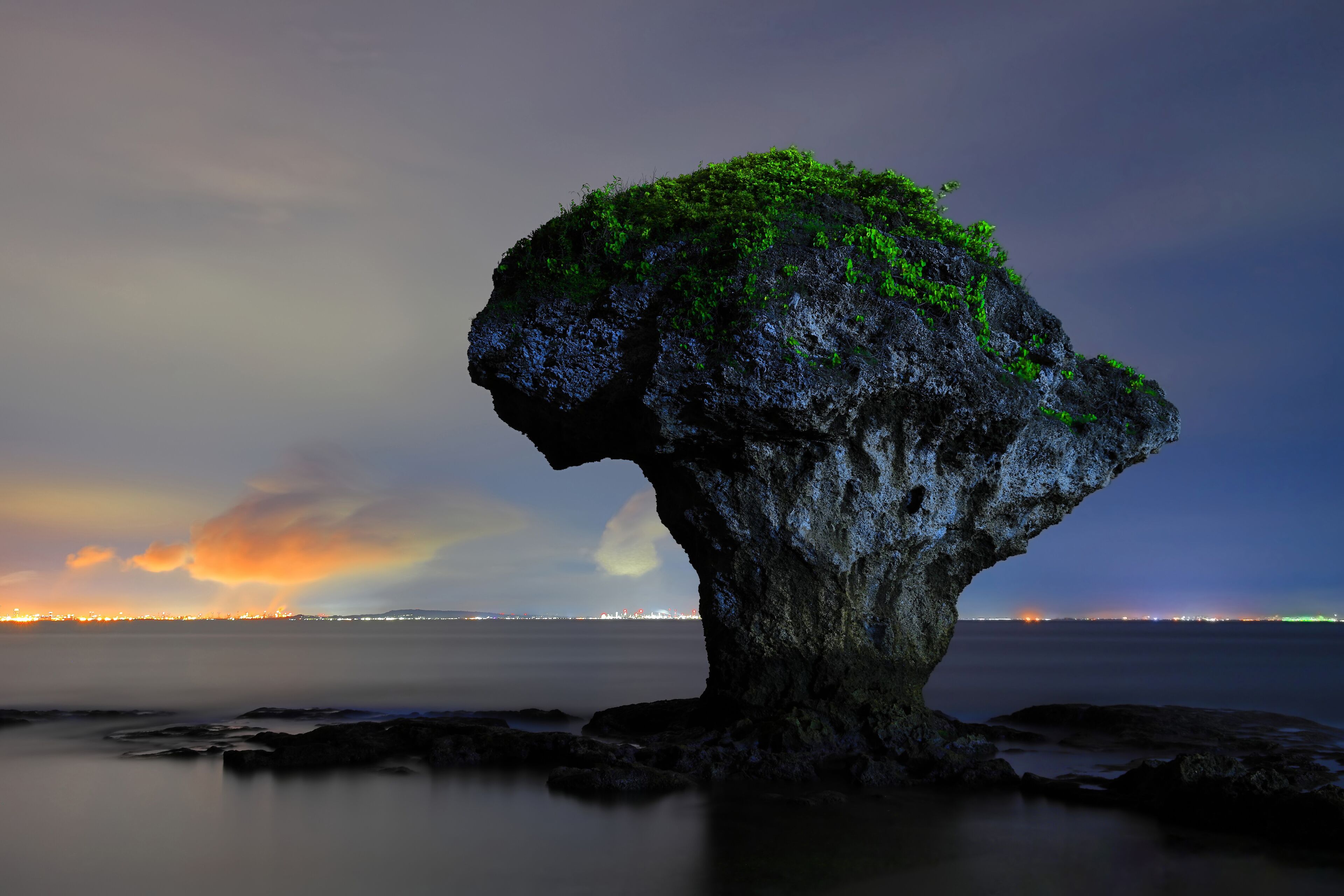 The vase-shaped rock on the sea and  beautiful cloud illuminated by the light of land city.Liuqiu,Pingtung,Taiwan,for branding,calender,postcard,screensave,wallpaper,poster,website.High quality photo