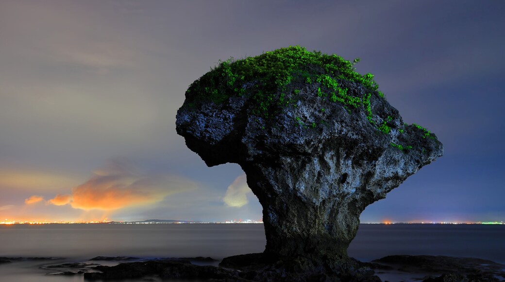 The vase-shaped rock on the sea and beautiful cloud illuminated by the light of land city.Liuqiu,Pingtung,Taiwan,for branding,calender,postcard,screensave,wallpaper,poster,website.High quality photo
