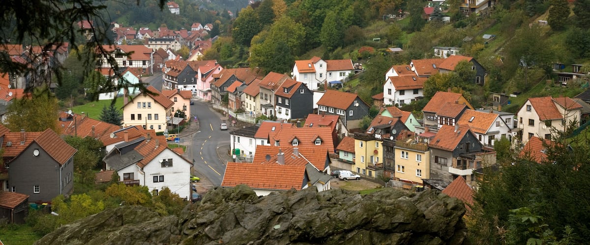 A hillside village with red-roofed houses and lush greenery.