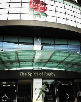 Un edificio con un gran logotipo de rosa y el texto 'The Spirit of Rugby' en la fachada.