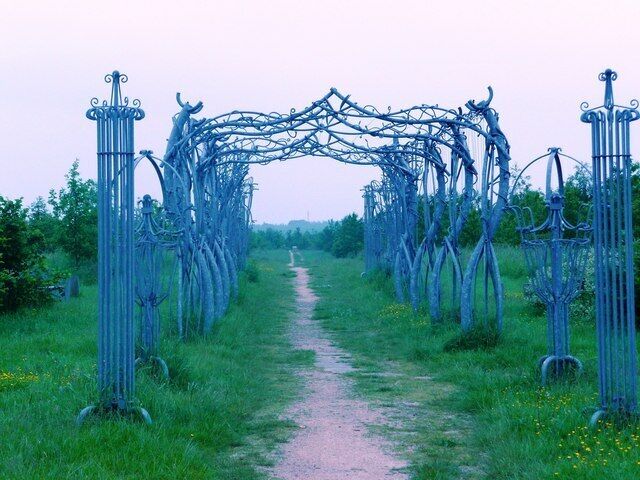 Un arco de metal en un campo cubierto de hierba.