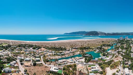 Aerial drone panoramic view of Troia, a peninsula located in Grandola Municipality, next to Sado River estuary, with Arrabida mountain range on left, Alentejo, Portugal