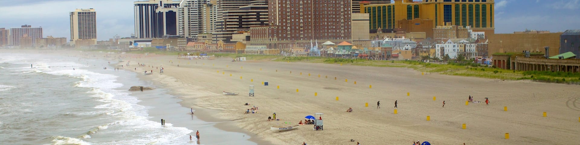 A beach with Atlantic City boats, Tropicana hotel, and various buildings.