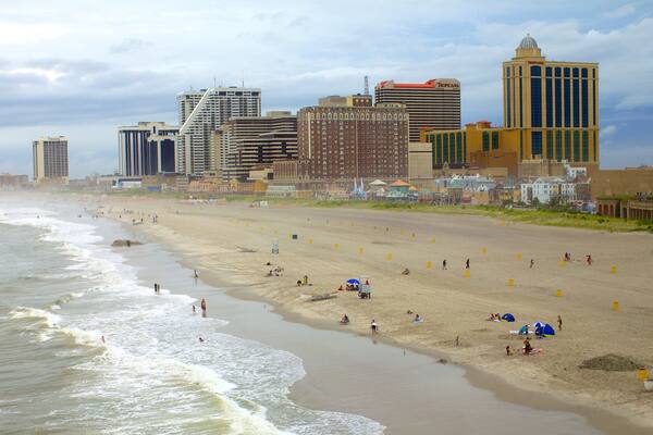 A beach with Atlantic City boats, Tropicana hotel, and various buildings.